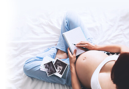 Schwangere Frau mit Ultraschallbildern
